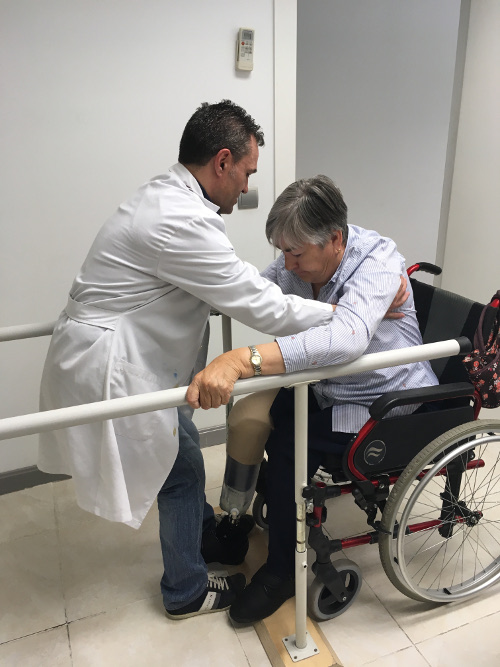 Profesional ayudando a paciente en silla de ruedas