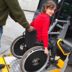 Mujer con discapacidad subiendo la rampa para acceder al taxi